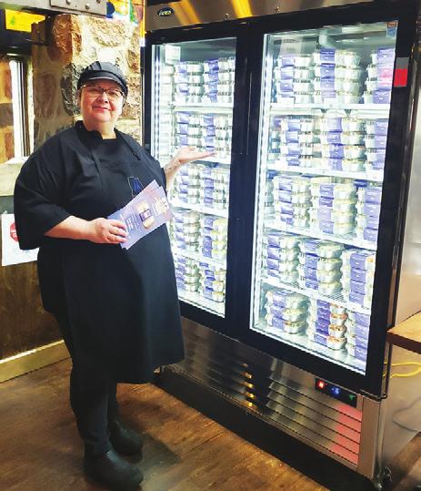 Brasserie Manoir Executive Chef Chantal Sauvé stands next to a freezer full of the ready-to-eat meals