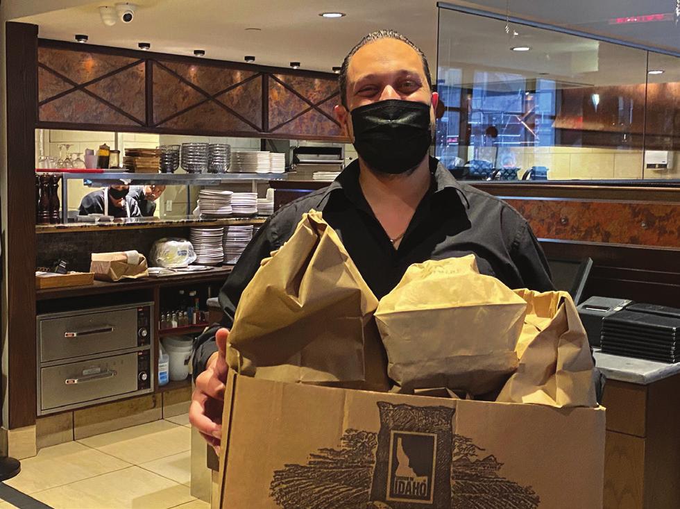 Co-owner Spyro Theo presenting a two-family take-out order